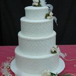 Ivory 4-Tiered Step Cake is covered in elegant ivory silk fabric trimmed with pearls & iridescent sequins. Ivory pearls circle the base of each tier. Lace & pearl trim circles the top of each tier. Ivory fabric flowers with ribbons set on the side of each tier. Very elegant for large weddings.  