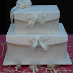 White Double Stacked Boxes are covered in white bridal brocade. White satin ribbons on front flaps of boxes can be changed to coordinate with bridal colors. Pearls trim the base of each layer. Simple but elegant.