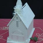 Ivory Church is covered with satin fabric with silver sequins. Ivory roses with rhinestones decorate the corners of the base. Streaming flowers adorn the front of the steeple. Great for small weddings or bridal showers.